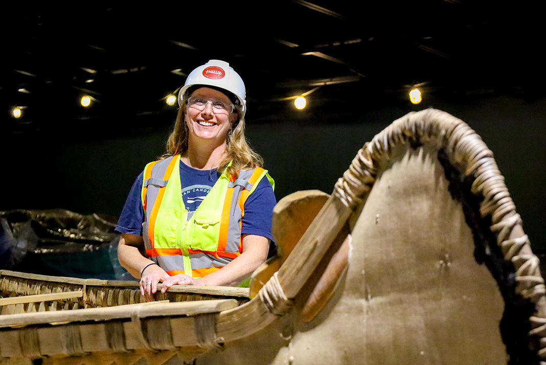 Carolyn Hyslop, Executive Director of The Canadian Canoe Museum, smiles while moving a large birch bark canoe into the new Exhibition Hall. The Canadian Canoe Museum stewards the world’s largest collection of canoes, kayaks, and paddled watercraft. (Photo: The Canadian Canoe Museum)