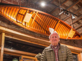 Bill Dunlap poses in front of the Deliverance canoe at Wander North Georgia's store