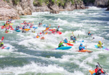 a group of kayakers taking part in a whitewater race, which the ICF has renamed from boatercross to "extreme slalom"
