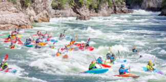 a group of kayakers taking part in a whitewater race, which the ICF has renamed from boatercross to "extreme slalom"