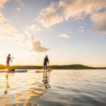 How To Buy The Best Hard Paddleboard For You two people paddling on hard paddleboards at dawn