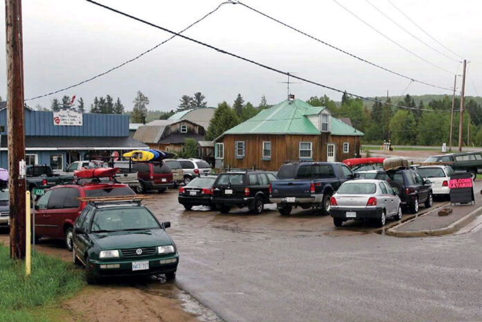 a group of cars parked in a paddling town with kayaks on top