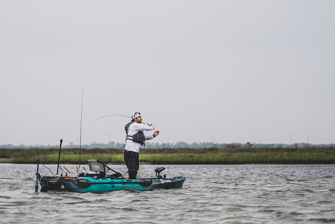 kayak angler standing and casting for redfish on a cloudy day in Texas