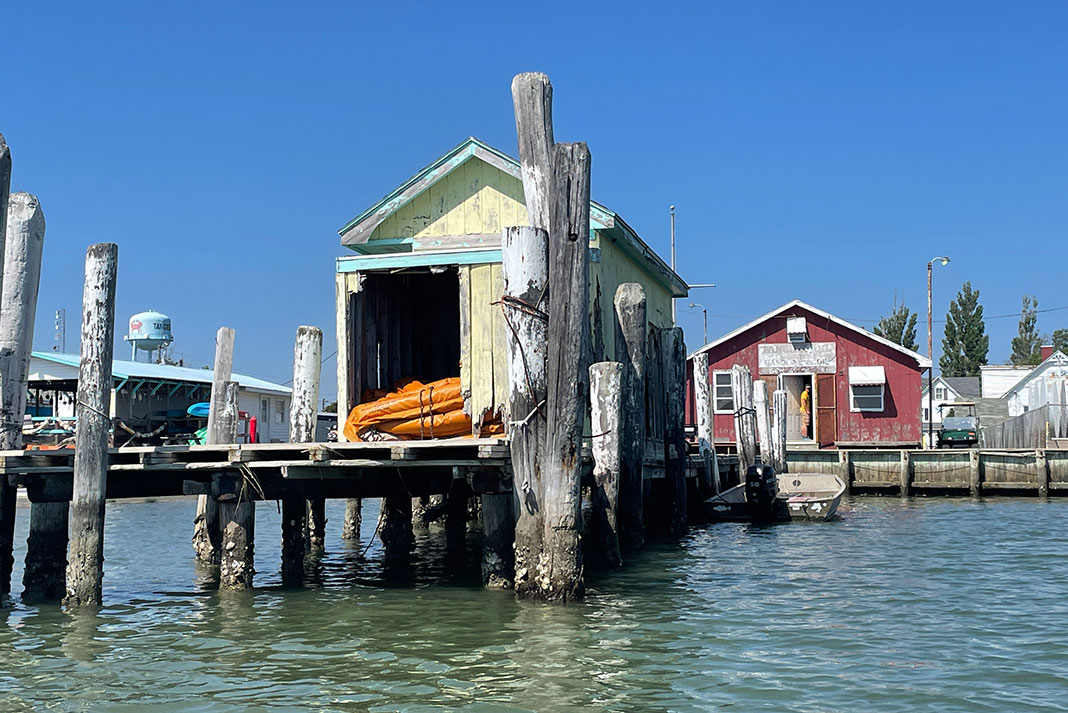 a colorful outbuilding sits on a pier