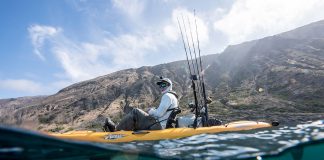 person on yellow fishing kayak pedals a drive with fins