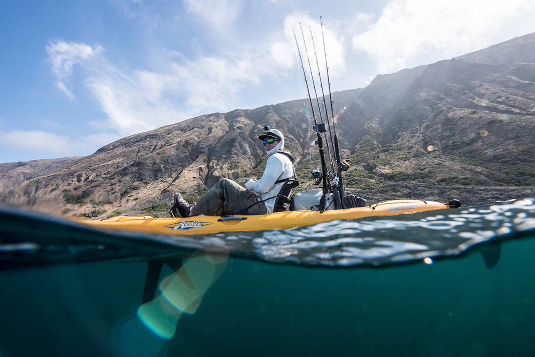 person on yellow fishing kayak pedals a drive with fins