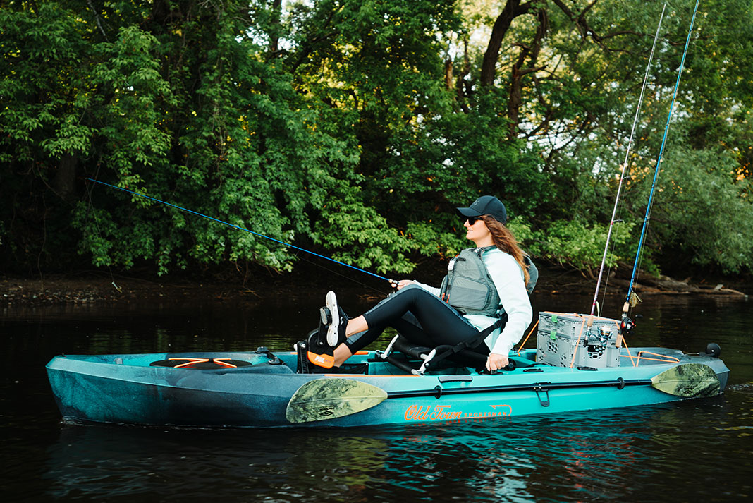 woman pedals an Old Town fishing kayak