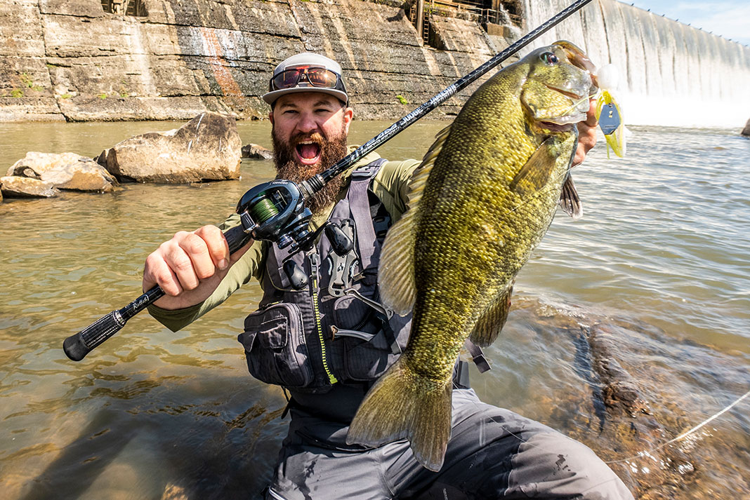 man yells as he holds up a smallmouth bass
