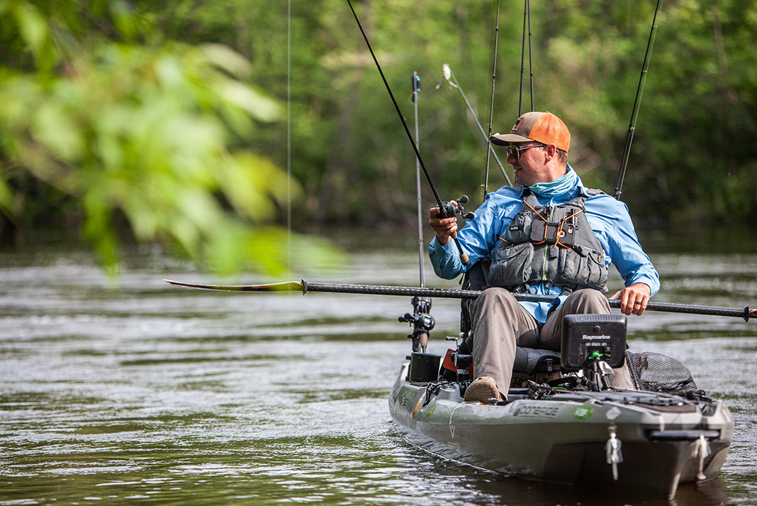 man fishes for smallmouth bass from his kayak