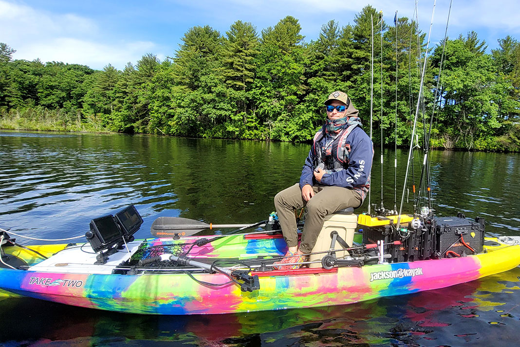 kayak angler sits on his Jackson fishing kayak equipped with trolling motor