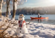 winter snowman with kayak angler blurred out in background