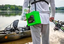 man carries Norsk batteries and fishing rods to his kayak