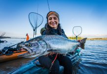 Ashley Nichole Lewis poses with a salmon caught on her fishing kayak