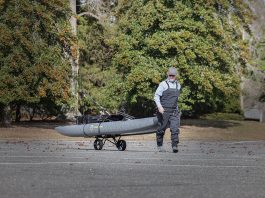 man pulls an NRS inflatable kayak on a heavy duty kayak cart