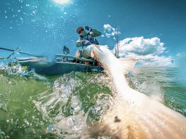 fisheye photo of a kayak angler hauling in a fish
