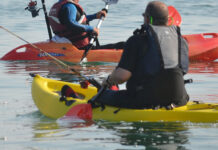 People paddling small, plastic fishing kayaks