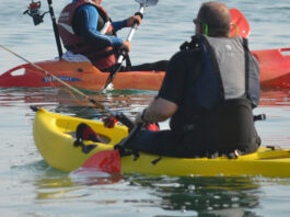 People paddling small, plastic fishing kayaks