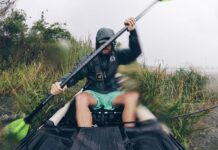 Find The Perfect-Sized Paddle For Your Fishing Kayak man paddles a fishing kayak with a perfect size paddle