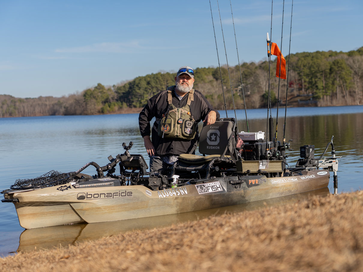 Chad Hoover standing next to Bonafide PWR129 fishing kayak.