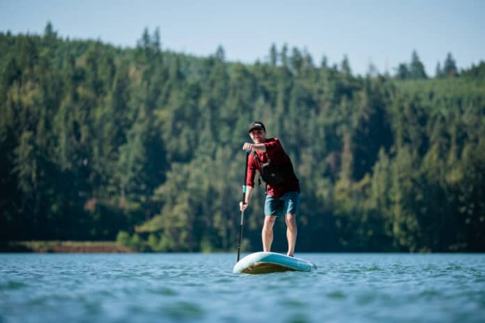 Niphean inflatable paddleboard being used on lake.