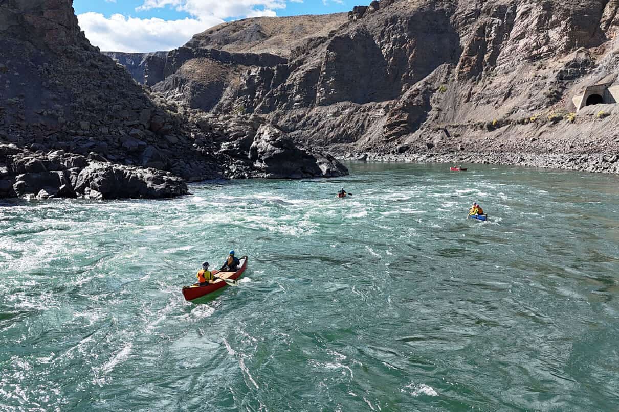 canoes on whitewater surrounded by rocky canyon walls