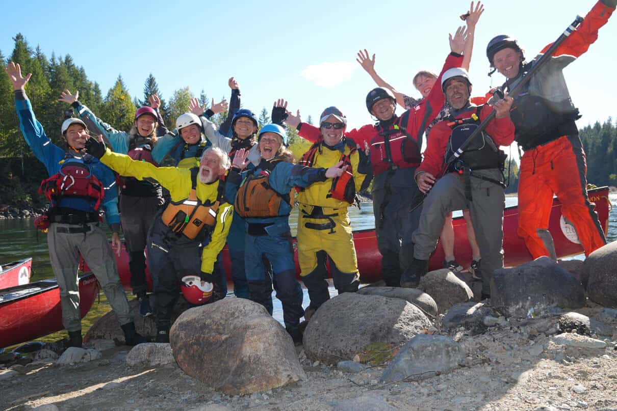 a group of whitewater canoeists pose in their paddling gear