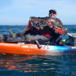 Author Kevin Hofer holds up a large lingcod caught while kayak fishing