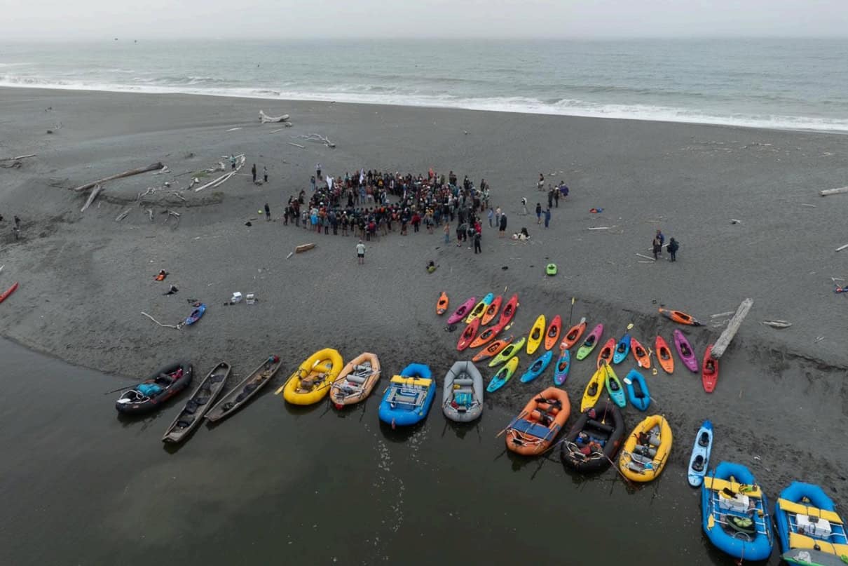(Paddle Tribal Waters youth, family and tribal members and supporters form a ceremonial circle Friday on the sand spit at the mouth of the Klamath River Friday).