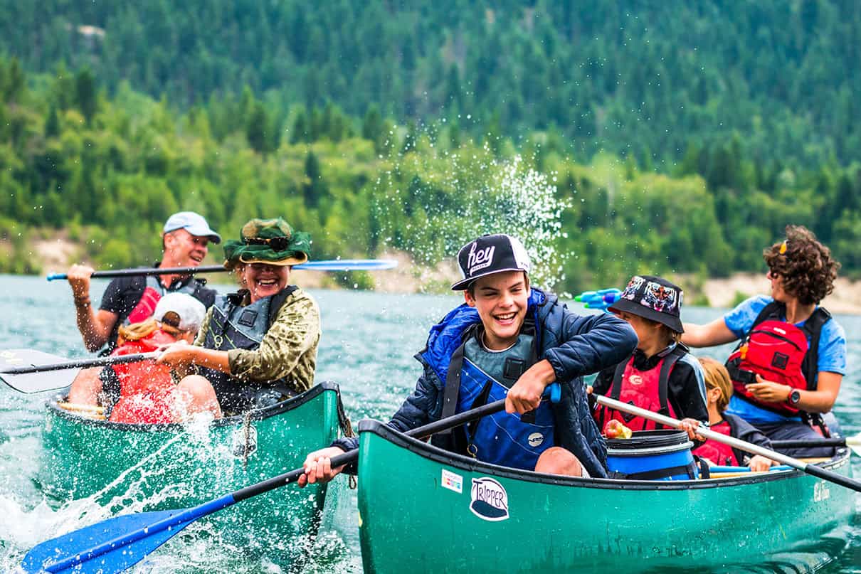 People in two canoes splash each other with water on the Columbia River.