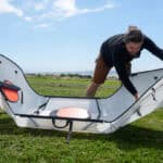 Best Foldable Kayaks For 2026 Man folding a portable kayak into shape.