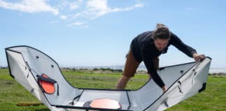 Man folding a portable kayak into shape.