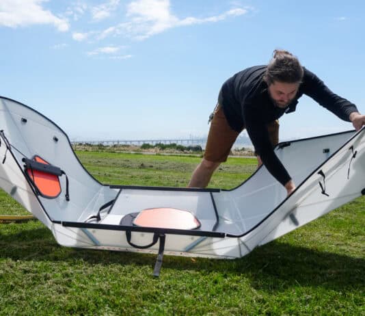 Man folding a portable kayak into shape.