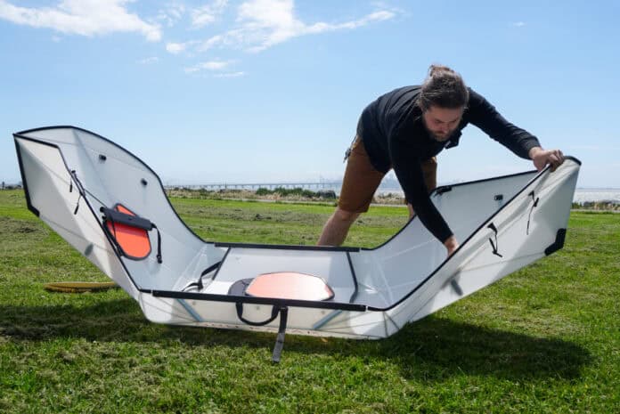 Man folding a portable kayak into shape.
