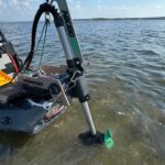 Newport Vessels trolling motor attached to kayak on water.