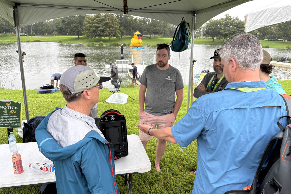 Group of anglers looking over a prototype kayak motor in Orlando.
