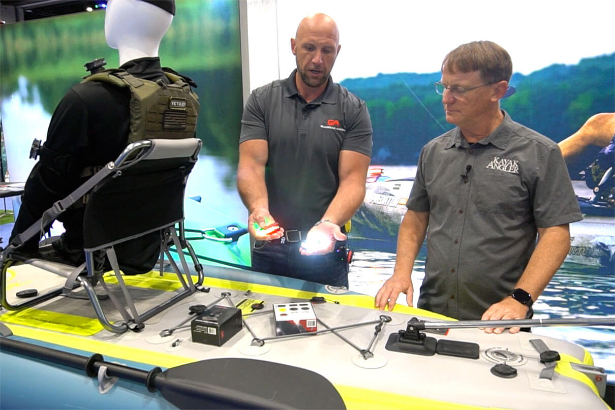 Chadwick Keller from Guardian Angel demonstrates their kayak lighting products to Kayak Angler editor Ric Burnley at ICAST 2025
