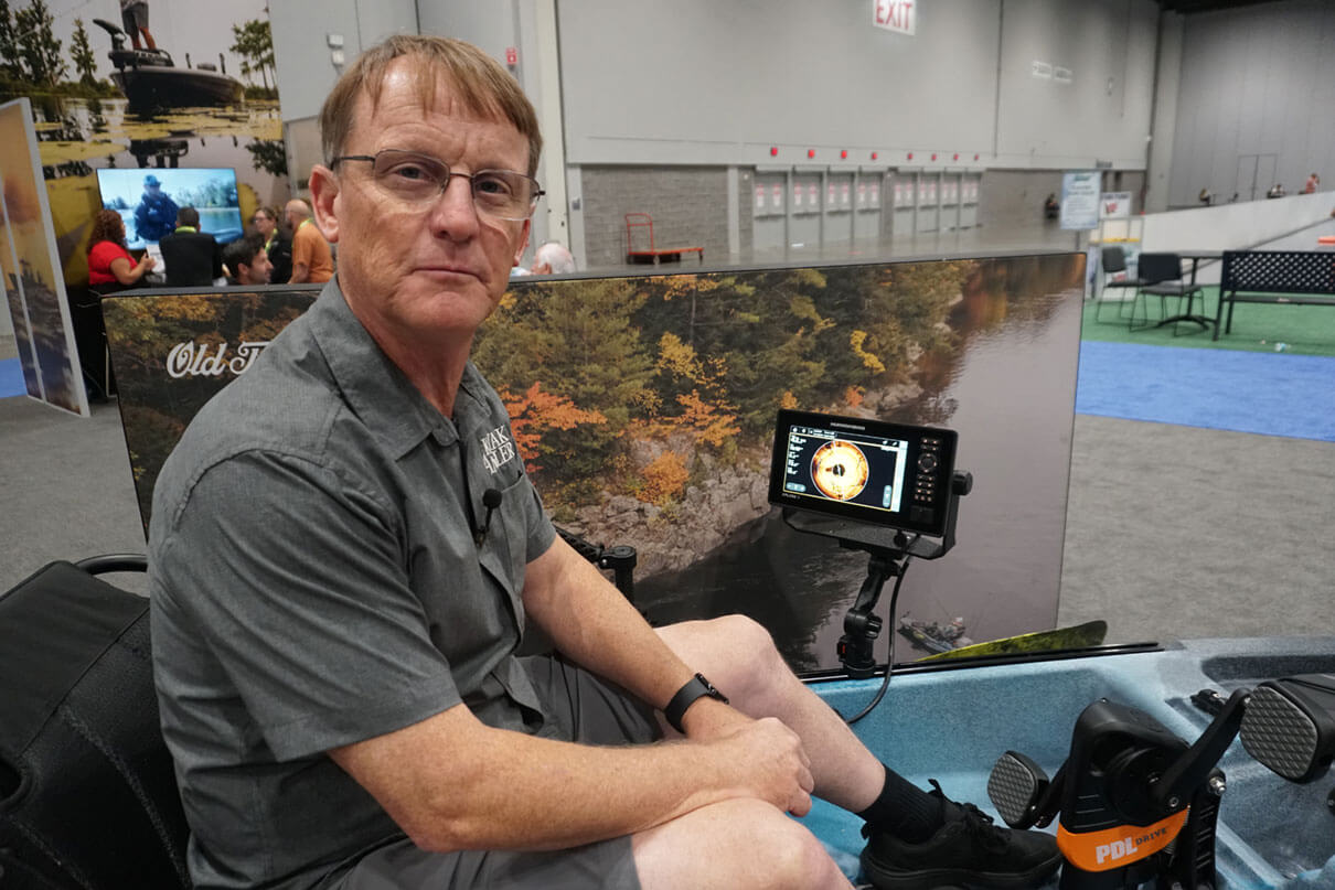 Ric Burnley sits in a demo boat outfitted with Humminbird's XPLORE fish finder displays at ICAST 2025