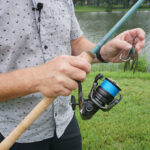 Man hold fish rod and lure in hands.