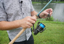 Man hold fish rod and lure in hands.