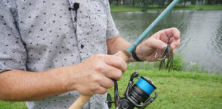 Man hold fish rod and lure in hands.