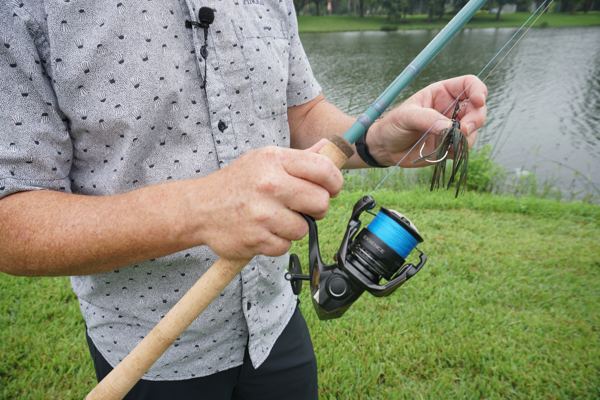 Man hold fish rod and lure in hands.