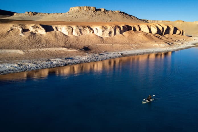 a man paddleboards on a high-altitude Chilean lake while setting the world record for highest elevation ever SUPed