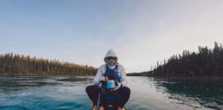 Craig Sawyer sits and eats on his paddleboard during the Yukon 1000 race