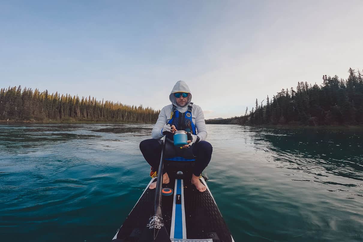 Craig Sawyer sits and eats on his paddleboard during the Yukon 1000 race