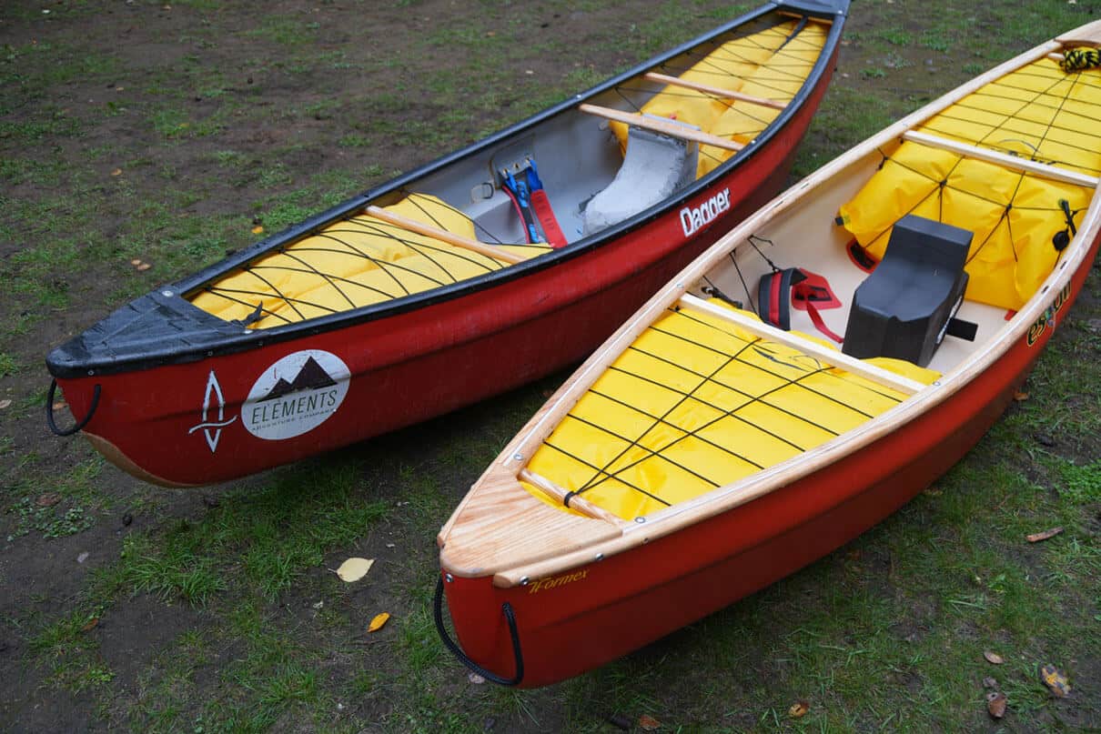 two new Esquif Ocoee solo whitewater canoes sit side-by-side on grass