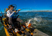 Image of Crystal Borkes on a fishing kayak pulling in a fish.