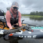Author Kevin Hughes shows a fish caught from his inflatable fishing kayak.