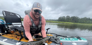 Author Kevin Hughes shows a fish caught from his inflatable fishing kayak.