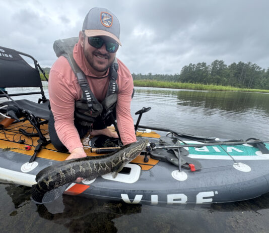 Author Kevin Hughes shows a fish caught from his inflatable fishing kayak.