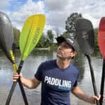 Best Kayak Paddles For 2025 Paddling Magazine editor Joe Potoczak holding up an assortment of the best kayak paddles on the market.